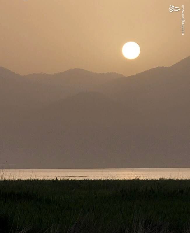 تصویری زیبا از خورشید در حال غروب در دریاچه‌ زیبای زریبار ، مریوان را مشاهده می کنید.